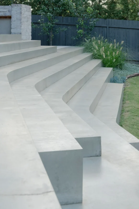 Sculptural concrete amphitheatre steps stepping down through Pymble backyard landscape