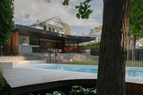 Rear view of Pymble home renovation with tiled pool, deck and modern extension by Lou Projects